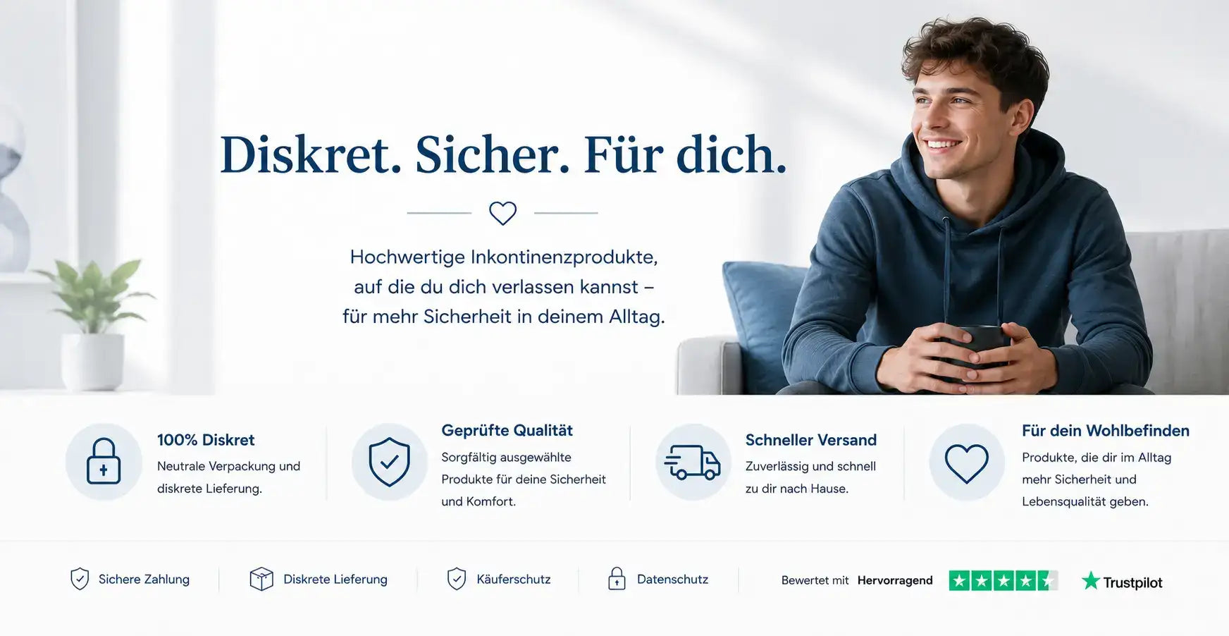 Ein Mann in einem dunkelblauen Hoodie sitzt auf einer Couch und hält ein schwarzes Smartphone.